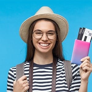 Smiling woman with passport and tickets, representing the online Schengen and UK ETA visa application
