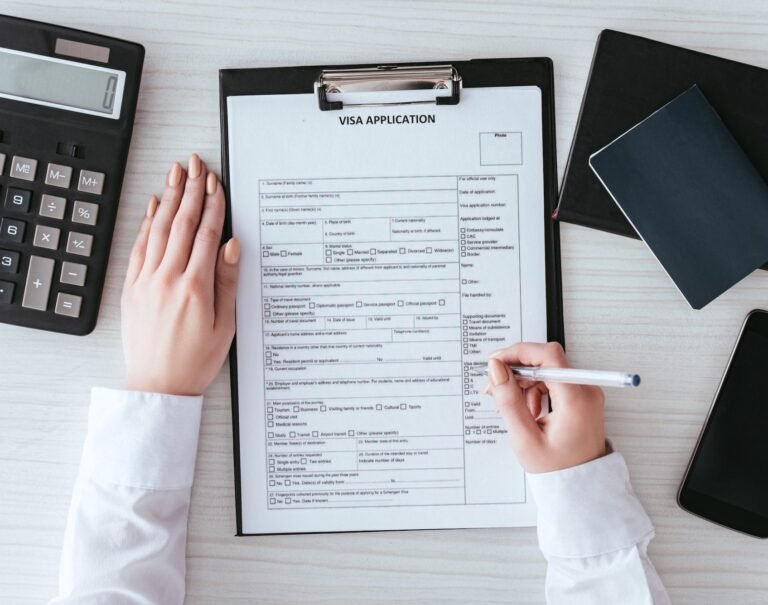Close-up of hands completing a visa application form, symbolizing assistance with European visa processing