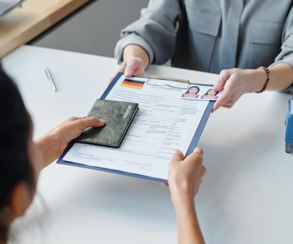 Submitting a visa application form and passport, representing professional European visa application assistance