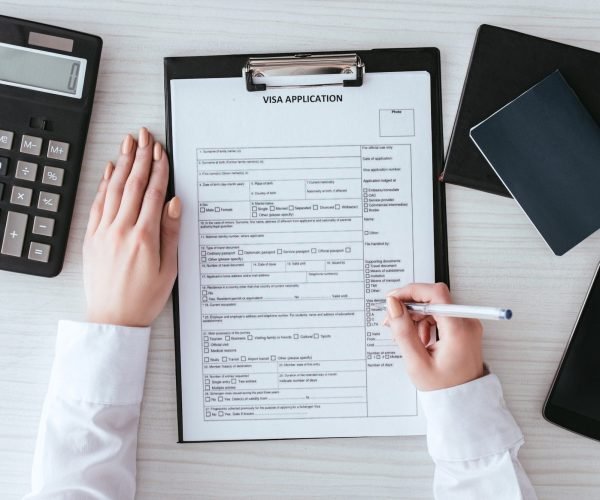 Close-up of hands completing a visa application form, symbolizing assistance with European visa processing