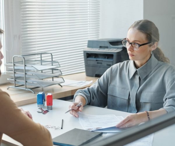 Client meeting with an immigration agent in an office to process a visa application, showcasing the formal visa application process