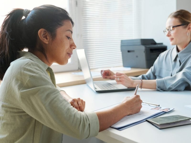 Woman filling out a visa application form during a consultation with a European immigration advisor